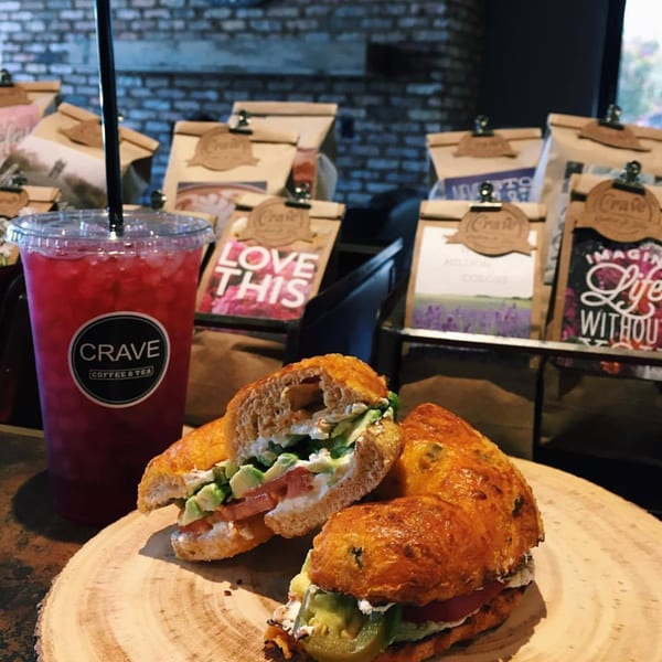 A Crave Coffee & Tea iced drink and two bagel halves with cream cheese, avocado, and tomato.